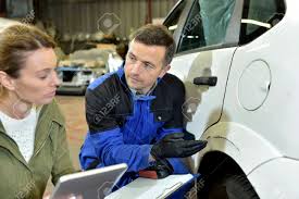 Mechanician With Insurance Adjuster Checking On Auto Repair