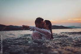 romantic couple kissing in the sea at