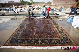 indians work on hand knotted carpet in
