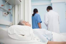 paziente sdraiato sul letto accanto a un medico e un&#39;infermiera 993678 Foto d&#39;archivio