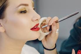 makeup artist applying red lipstick