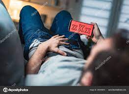 Man Holding Modern Smartphone Cellphone Watching Videos Home Couch Taboo  Stock Photo by ©milangucci 355229010