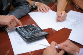 Business People Calculating Budget Together In Office Stock Photo