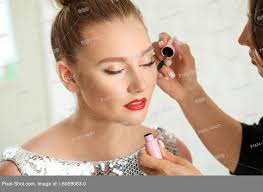 makeup artist working with model in