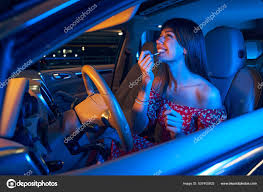young woman doing makeup in car