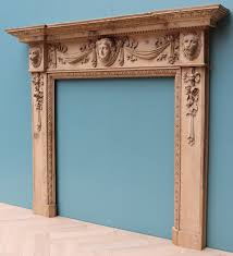 an antique carved pine fire surround in