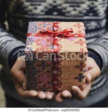 Woman giving christmas present to man. Young Man With A Christmas Gift Closeup Of A Young Caucasian Man Holding A Gift In His Hands Wrapped In A Nice Paper And Canstock