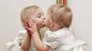 cute baby kissing a mirror with oneself