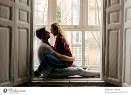 couple kissing on window sill a