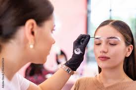 makeup artist applying a brow gel on