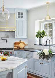In this galley style kitchen, space is maximized by the use of floor to ceiling cabinetry. Light Blue Kitchen Cabinets With Farmhouse Sink Transitional Kitchen